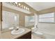 Bathroom featuring a large mirror, vanity, and tiled shower/tub combo at 9290 Lake Sharp Ct, Orlando, FL 32817