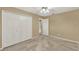 Neutral carpeted bedroom featuring a ceiling fan and a closet with white paneled doors at 9290 Lake Sharp Ct, Orlando, FL 32817