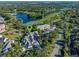 Aerial view of a home surrounded by lush landscaping, a golf course, and a lake at 9624 Bryanston Dr, Orlando, FL 32827