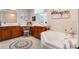 Large bathroom features dual sinks, a makeup vanity, and soaking tub underneath a glass block window at 9624 Bryanston Dr, Orlando, FL 32827