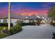 Beautiful exterior elevation of home with a circular drive, landscaping, and a stunning sunset sky at 9624 Bryanston Dr, Orlando, FL 32827