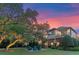 Beautiful home exterior at dusk with a manicured lawn, brick patio, and mature trees at 9624 Bryanston Dr, Orlando, FL 32827