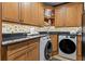Well-organized laundry room with custom wood cabinets, granite countertops, and modern washer and dryer at 9624 Bryanston Dr, Orlando, FL 32827