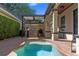 Outdoor space showcasing a small pool with an outdoor kitchen, grill, and a black pergola at 9624 Bryanston Dr, Orlando, FL 32827