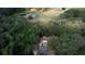 Aerial view of property with treeline, lake, and home with driveway and parked car at 9741 Se Highway 464C Se Hwy, Ocklawaha, FL 32179