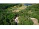Aerial view of property with treeline, lake, and home with driveway and parked car at 9741 Se Highway 464C Se Hwy, Ocklawaha, FL 32179