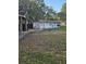 View of the exterior of the home surrounded by a lawn covered in leaves at 9741 Se Highway 464C Se Hwy, Ocklawaha, FL 32179