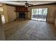 Spacious living room featuring a stone fireplace, ceiling fan, and sliding glass doors to outdoor space at 9741 Se Highway 464C Se Hwy, Ocklawaha, FL 32179