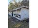 Outdoor white wood shed with shaded storage and attached door at 9741 Se Highway 464C Se Hwy, Ocklawaha, FL 32179