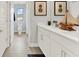 Bathroom with double vanity, decor, and tile flooring; a doorway leads to the toilet and shower at 11015 Hollow Bay Dr, Winter Garden, FL 34787