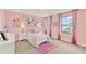 Pink bedroom with two windows, side tables with lamps, and a colorful art display at 11015 Hollow Bay Dr, Winter Garden, FL 34787