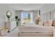Serene main bedroom with plush bedding, a large window, and neutral decor for a relaxing retreat at 11148 Amber Ridge Dr, Zellwood, FL 32798