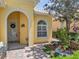 Inviting front entrance with a decorative door, arched entryway, and beautiful landscaping with colorful flowers at 11763 Eagle Ray Ln, Orlando, FL 32827