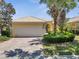 Charming home featuring a paver driveway, a two-car garage, manicured landscaping, and a barrel tile roof at 11763 Eagle Ray Ln, Orlando, FL 32827