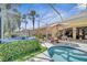 Private hot tub and pool in a screened lanai with serene views and tropical landscaping at 11763 Eagle Ray Ln, Orlando, FL 32827