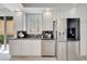 This kitchen offers a breakfast bar, granite countertops, white cabinets, and stainless steel appliances at 11763 Eagle Ray Ln, Orlando, FL 32827
