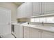 Laundry room with a large sink, white cabinets, and an updated washer and dryer at 11763 Eagle Ray Ln, Orlando, FL 32827