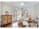 Music room featuring a white grand piano, hardwood floors, plantation shutters, and elegant decor at 11763 Eagle Ray Ln, Orlando, FL 32827