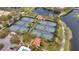 An aerial view shows multiple tennis courts next to a beautiful pond, offering great recreational activities at 11763 Eagle Ray Ln, Orlando, FL 32827