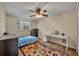 Functional bedroom with a bed, desk, dresser, ceiling fan, and colorful geometric rug at 1304 Deer Run Dr, Winter Springs, FL 32708
