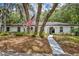 Charming white home with an American flag, trees, and lush landscaping at 1304 Deer Run Dr, Winter Springs, FL 32708