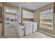 Functional laundry room with washer, dryer, storage cabinets, and natural light at 1304 Deer Run Dr, Winter Springs, FL 32708