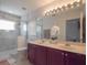 Bright bathroom with a double sink vanity, large mirror, and glass enclosed shower at 14242 Avenue Of The Groves, Winter Garden, FL 34787