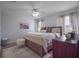 Bright primary bedroom with a ceiling fan, windows, hardwood floors and dresser at 14242 Avenue Of The Groves, Winter Garden, FL 34787