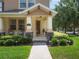 Inviting covered front porch with stone accents, rocking chairs, and well-manicured landscaping at 14242 Avenue Of The Groves, Winter Garden, FL 34787