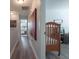 Hallway view featuring wood floors with bedroom with crib and primary suite at 14242 Avenue Of The Groves, Winter Garden, FL 34787