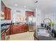 Spacious kitchen featuring ample counter space, stainless steel appliances, and cherry wood cabinetry at 14242 Avenue Of The Groves, Winter Garden, FL 34787