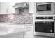 Contemporary kitchen with stainless steel appliances, stylish backsplash and modern cabinetry at 16195 Point Rock Dr, Winter Garden, FL 34787