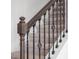 Close up of staircase with dark wood handrail and decorative iron spindles at 16195 Point Rock Dr, Winter Garden, FL 34787