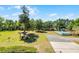 Aerial view of backyard featuring grill, above ground pool, storage shed, and driveway at 16692 Lake Pickett Rd, Orlando, FL 32820