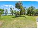 Aerial view of backyard featuring grill, storage shed, manicured lawn, and lake beyond at 16692 Lake Pickett Rd, Orlando, FL 32820
