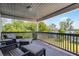 A covered balcony features seating with a beautiful view of the outdoors and the lake at 16692 Lake Pickett Rd, Orlando, FL 32820