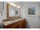 Bathroom vanity with granite countertop, gold trimmed mirror, and window with shuttered blinds at 16692 Lake Pickett Rd, Orlando, FL 32820