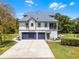 Spacious home featuring a three-car garage, large driveway, and well-maintained lawn at 16692 Lake Pickett Rd, Orlando, FL 32820