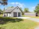 Detached two-car garage with additional covered parking and grassy lawn at 16692 Lake Pickett Rd, Orlando, FL 32820