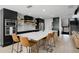 Eat-in kitchen features a large island with seating, black cabinets, and modern appliances at 16692 Lake Pickett Rd, Orlando, FL 32820