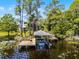 Boat dock on a lake with lily pads and mature trees at 16692 Lake Pickett Rd, Orlando, FL 32820