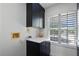 Efficient laundry area with ample cabinet space, white countertops, and natural light from the window at 16692 Lake Pickett Rd, Orlando, FL 32820