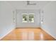 Bright bedroom features wood floors, white walls, and natural light from three windows at 1702 N Westmoreland Dr, Orlando, FL 32804
