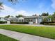 Traditional home boasts a well-kept lawn, manicured shrubs, and mature trees, offering great curb appeal at 1702 N Westmoreland Dr, Orlando, FL 32804