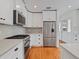 Bright kitchen features white cabinets, modern appliances, quartz countertops, and hardwood floors at 1702 N Westmoreland Dr, Orlando, FL 32804