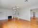 Bright living room boasts hardwood floors, white trim, fireplace, and views into the kitchen and entry at 1702 N Westmoreland Dr, Orlando, FL 32804