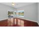 Bright bedroom features hardwood floors and a view of the sparkling pool through the window and sliding glass doors at 1851 Sweetwater West Cir, Apopka, FL 32712