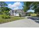 Lovely exterior view of home with a large driveway, manicured lawn, and neatly trimmed landscaping at 1851 Sweetwater West Cir, Apopka, FL 32712