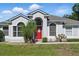 Close-up of the home's front exterior, featuring a red door and well-kept landscaping at 1851 Sweetwater West Cir, Apopka, FL 32712