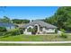 Charming single-story home with a well-manicured lawn, red door, and tasteful landscaping at 1851 Sweetwater West Cir, Apopka, FL 32712